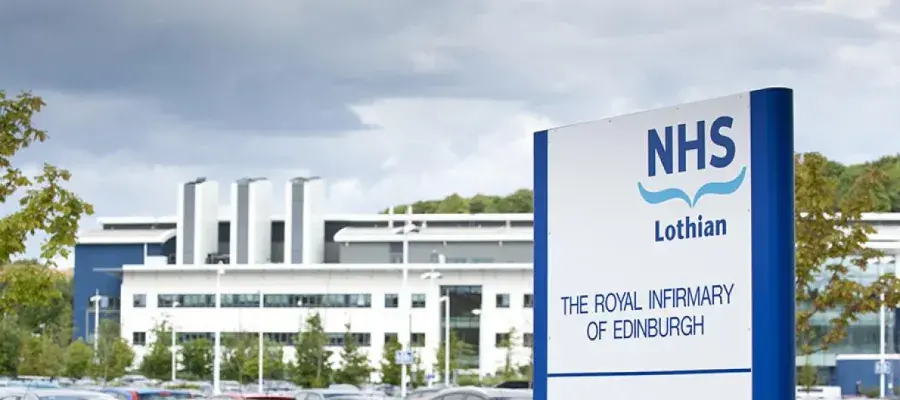 NHS sign with hospital buildings in distance